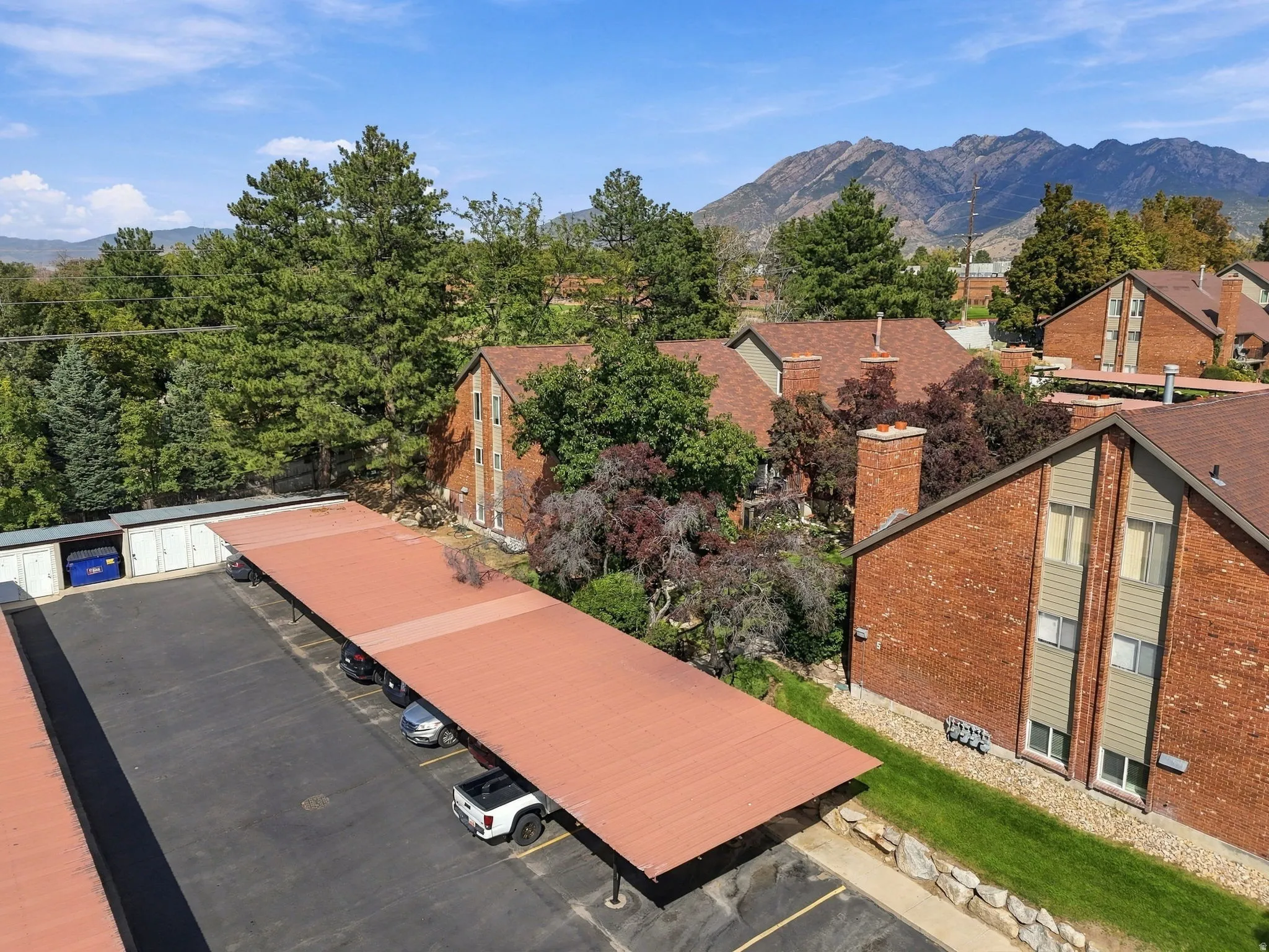 Community featuring brick exteriors, pitched roofs, covered parking, and mountain scenery