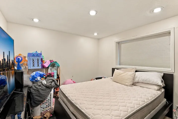 Recessed lighting, a window with white trim, and light-colored walls