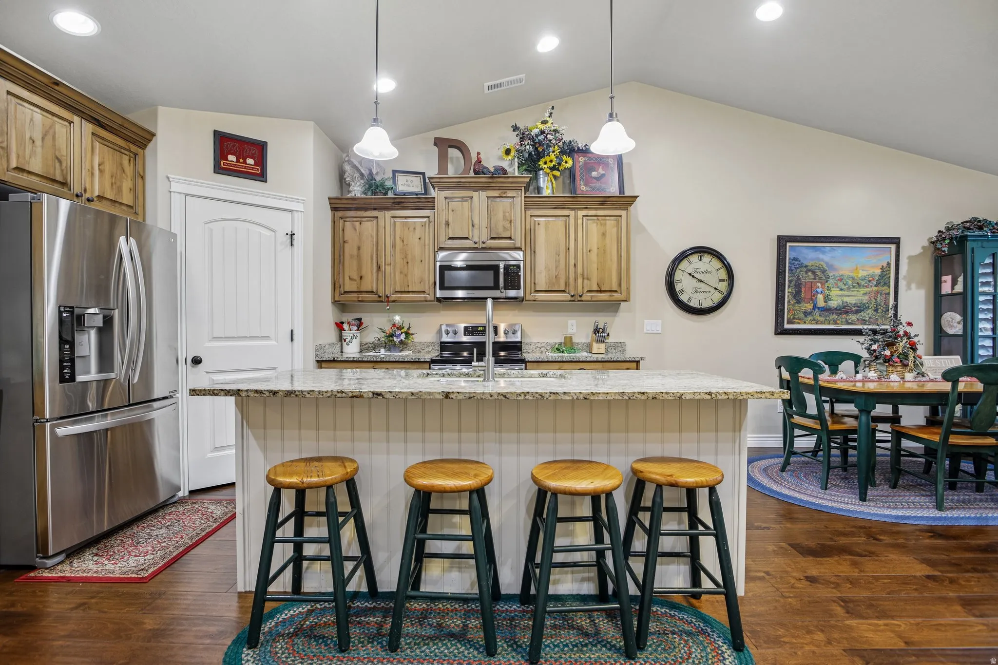 Kitchen featuring wood-finish cabinetry, stainless steel appliances, a center island with granite countertops, and recessed lighting