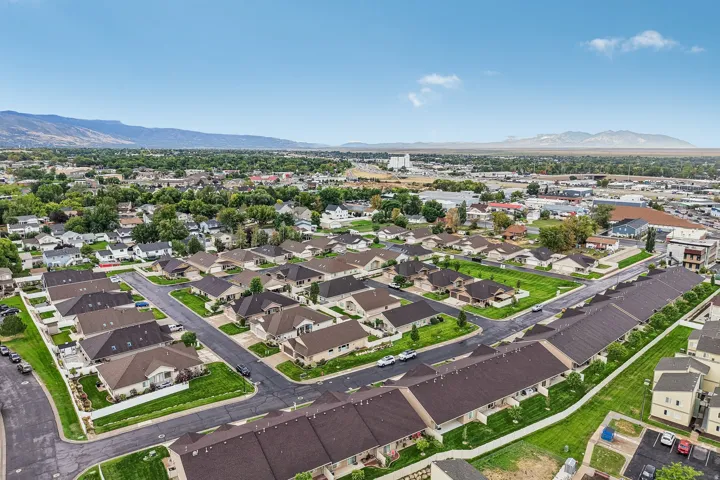 Residential development with a mix of single-family homes and multi-story townhomes, featuring paved streets and manicured green spaces