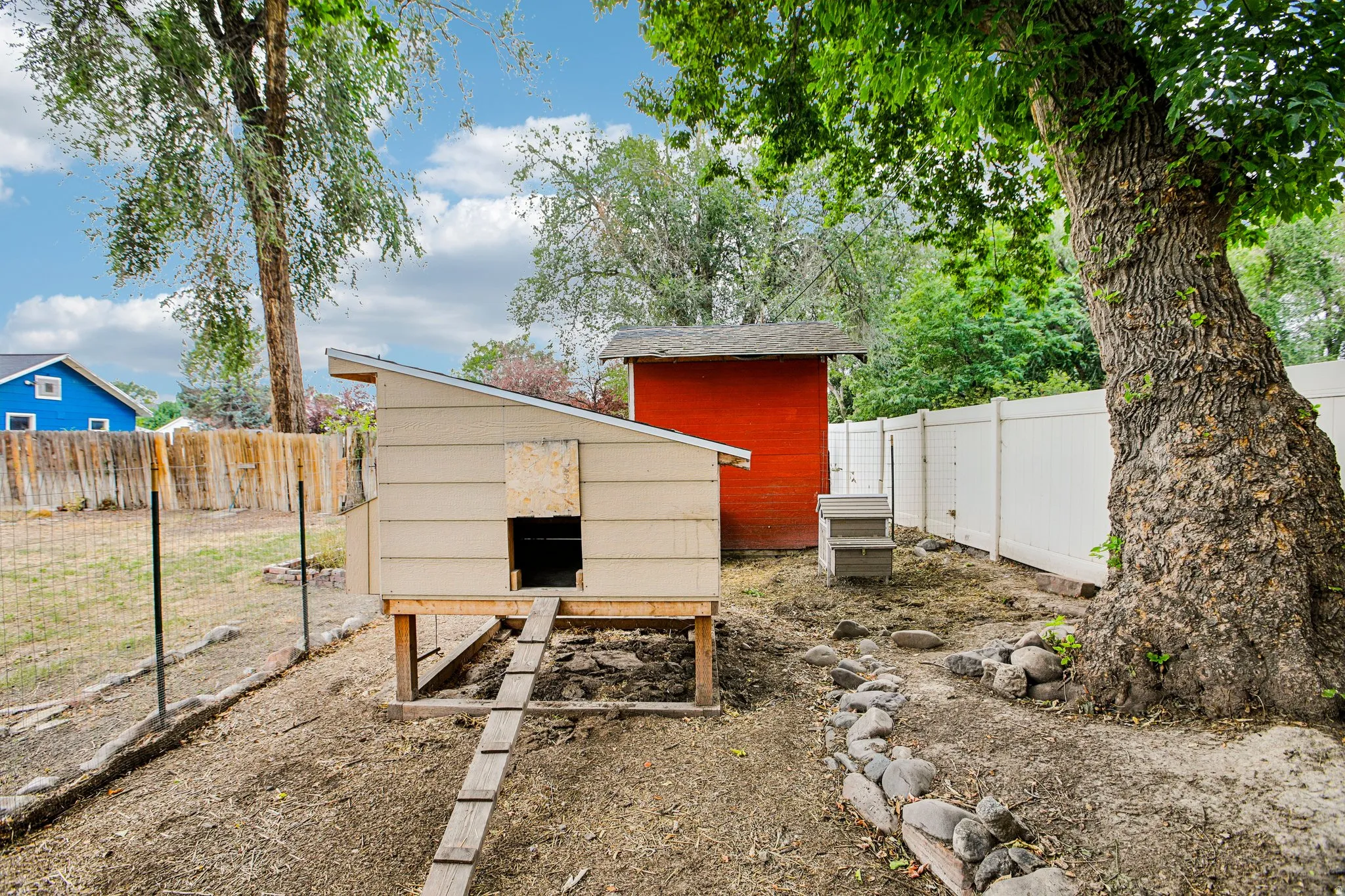 Established backyard featuring mature trees, a privacy fence, and an accessory structure