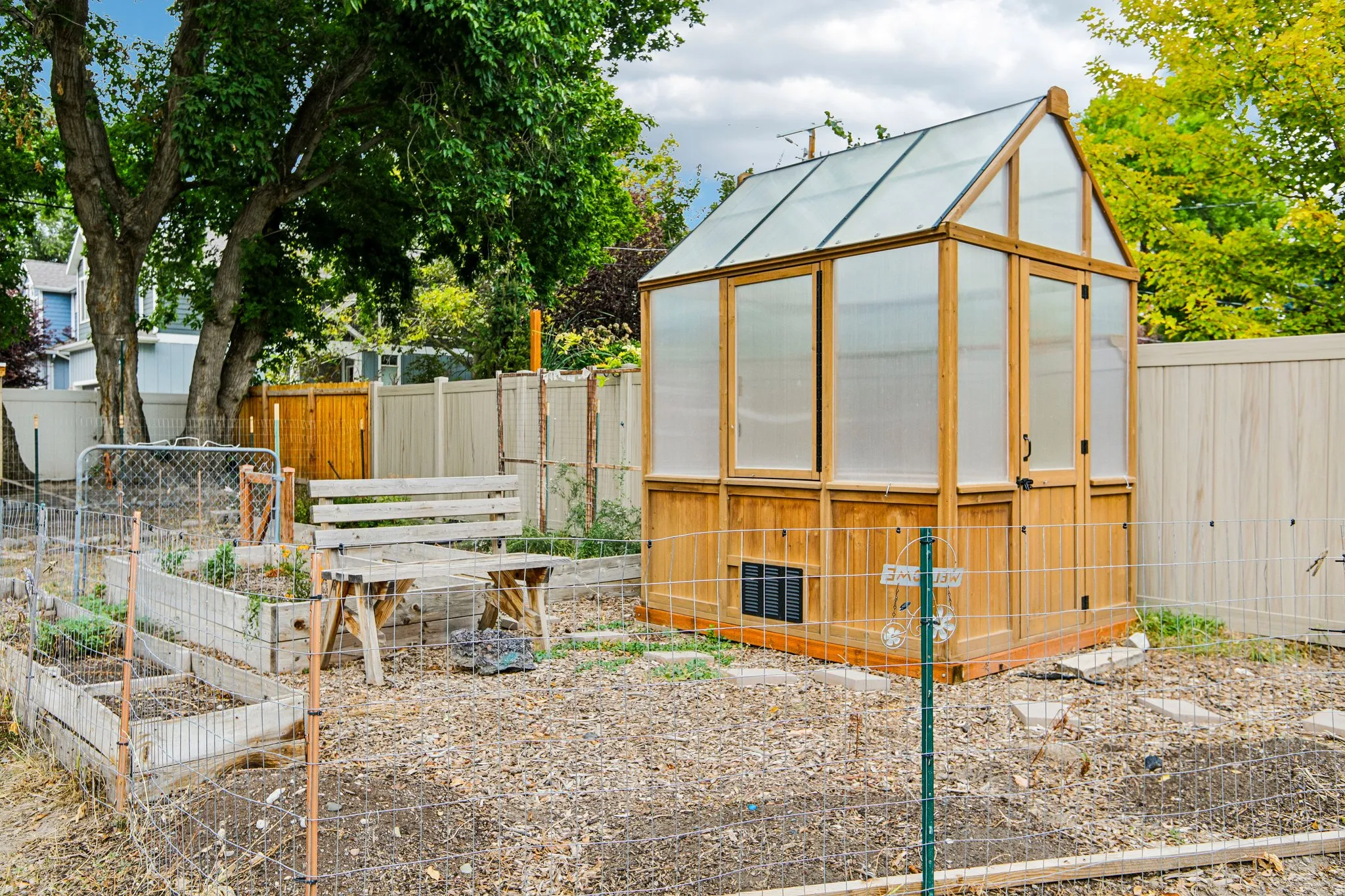 Wood-framed greenhouse with a clear roof and translucent paneling