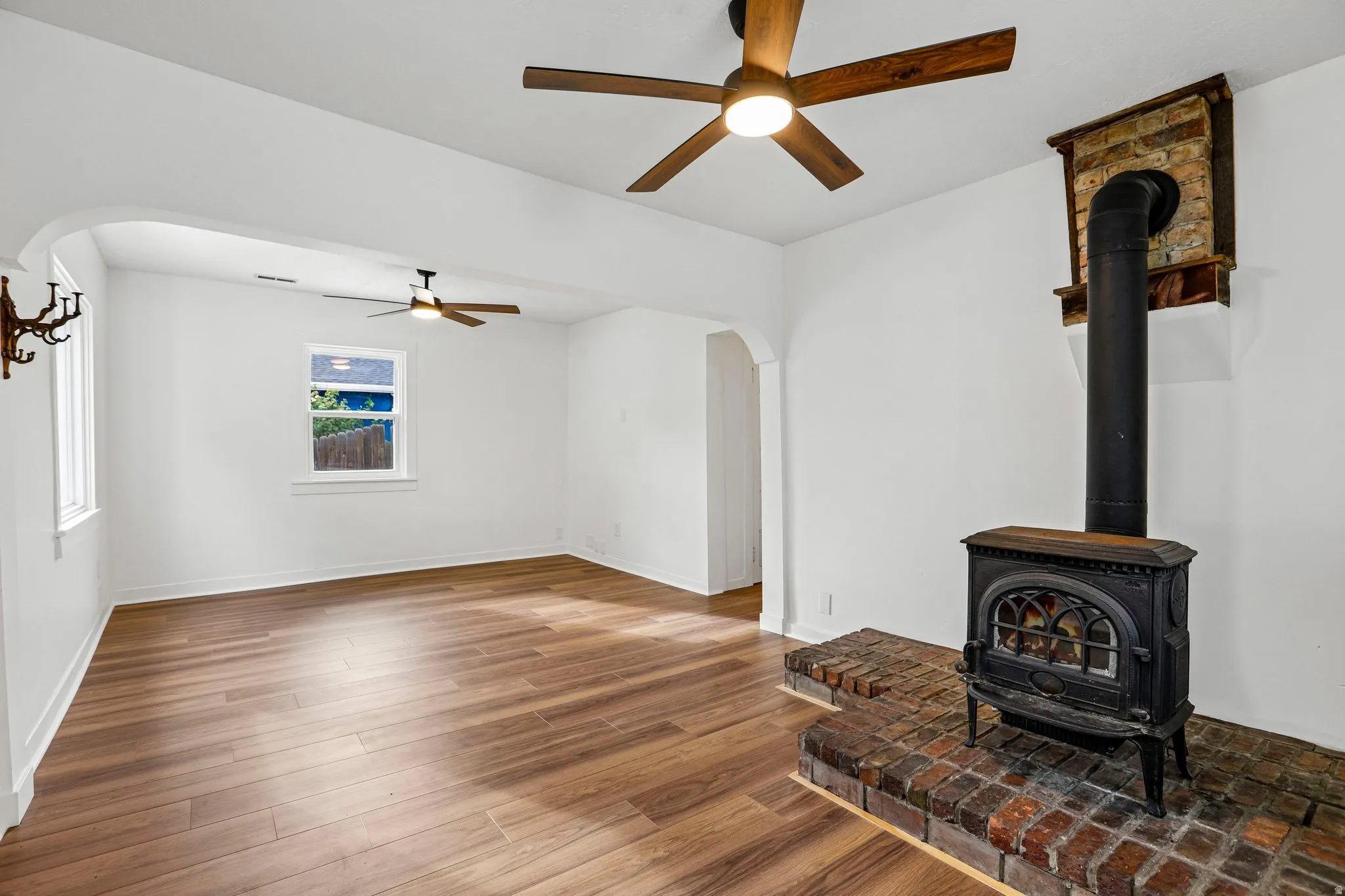 Wood-finish flooring throughout, with a cast iron wood stove on a brick hearth