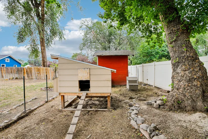 Established backyard featuring mature trees, a privacy fence, and an accessory structure