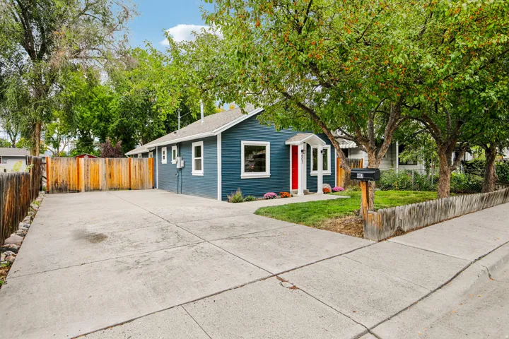 Blue siding exterior with white trim, red front door, and a concrete driveway