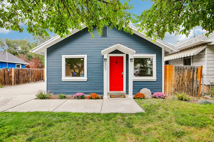Blue horizontal siding with white trim, a vibrant red front door, and a covered entry