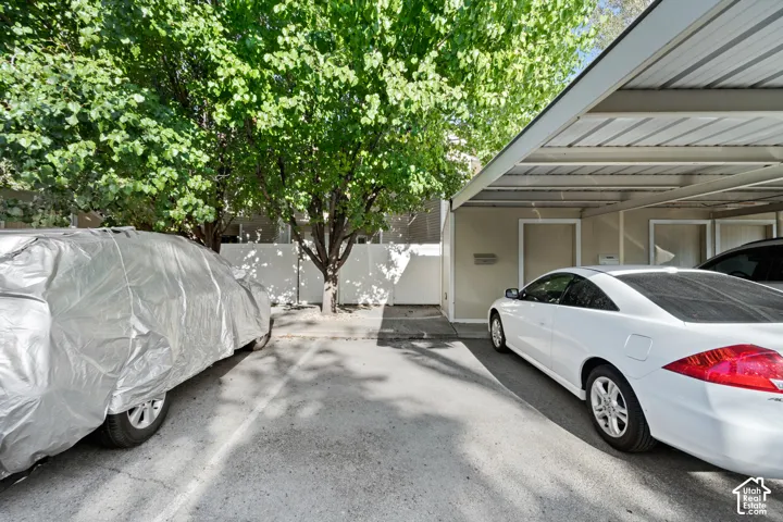 Covered parking structure with a corrugated metal roof and a dedicated parking space