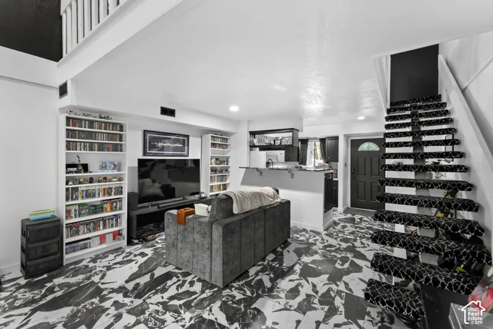 Black and white patterned flooring, white walls, black accent wall, and a staircase with patterned risers