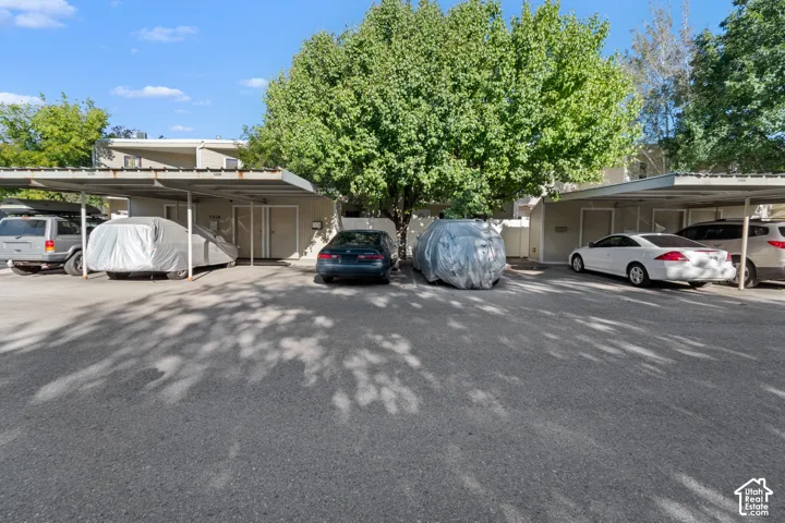 Covered parking structures with multiple parking spaces and mature trees providing natural shade