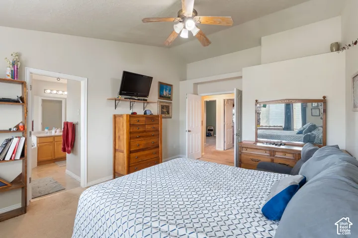 Vaulted ceiling featuring a central multi-blade light fixture, neutral wall palette, and dual-panel interior doors