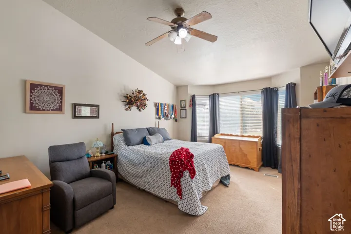 Vaulted ceilings, bay window, and a ceiling fan with integrated lighting