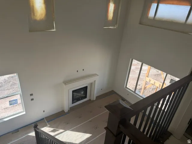 Built-in fireplace with a white mantel, dark wood newel posts, dark wood balusters, and transom windows