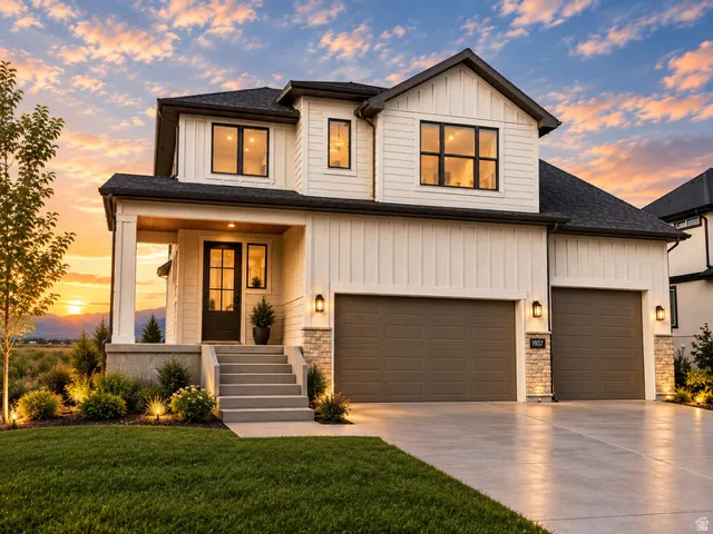Contemporary two-story exterior with board and batten siding, stone accents, a covered front porch, and a two-car garage