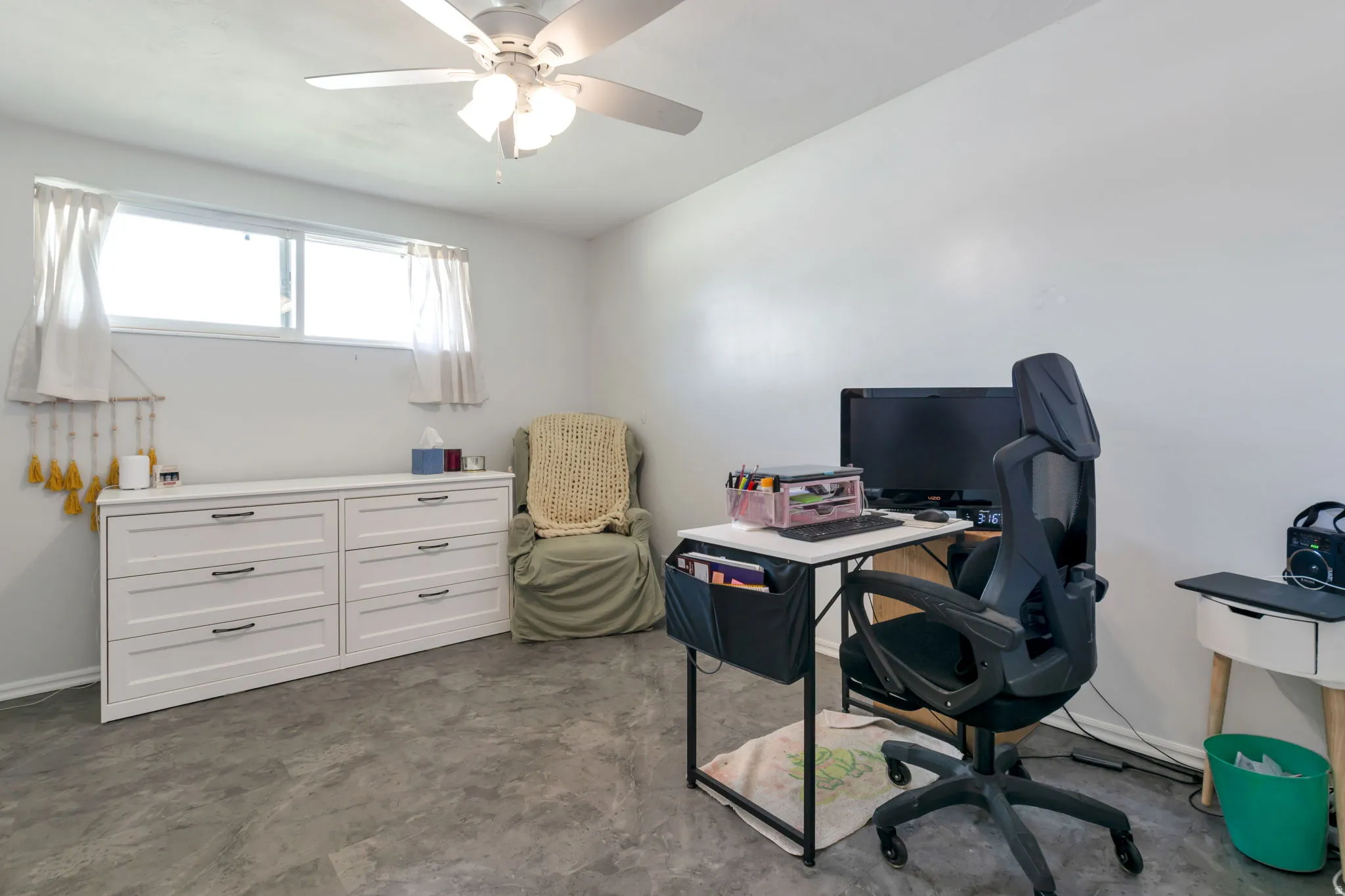 Recessed horizontal window, ceiling fan with integrated lighting, and gray-toned flooring