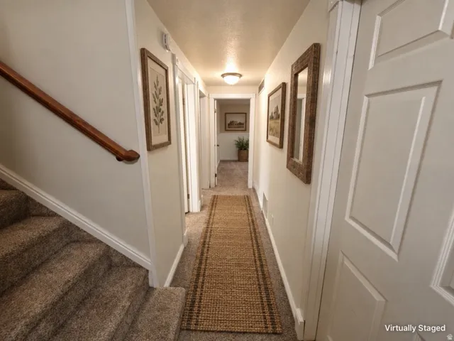 Carpeted staircase with a wood handrail