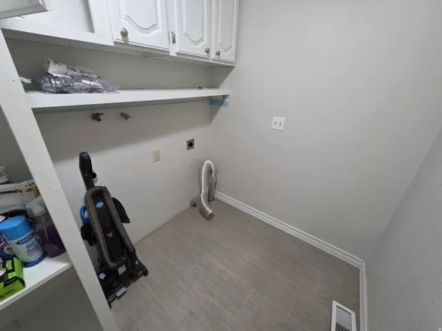 White cabinetry with silver hardware, open shelving, and light wood-finish flooring
