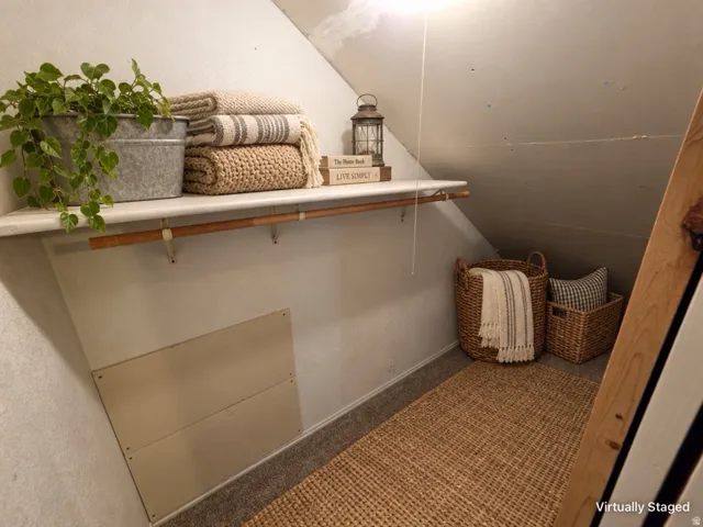 Built-in shelving with a hanging rod, sloped ceiling, and carpeted flooring