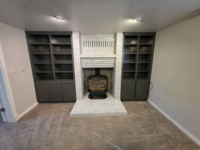 White-painted brick fireplace with a wood-burning stove insert
