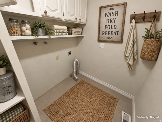 Built-in cabinetry, upper shelving, and tile flooring