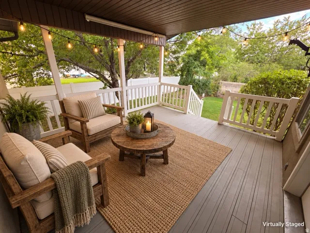 Expansive covered deck with painted wood flooring and white railings