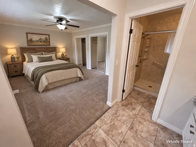 Carpeted bedroom with a ceiling fan, dual sliding mirror closet doors, and recessed lighting