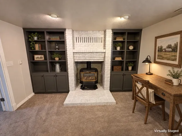 Built-in shelving units, brick fireplace with stove insert, and neutral carpet flooring
