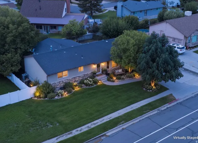 Pitched roof, stone façade accents, mature trees, manicured lawn, and pathway lighting
