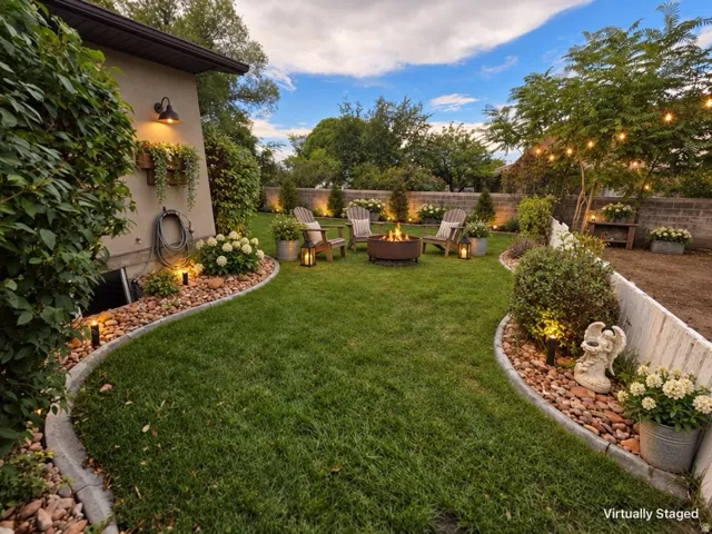 Manicured lawn with a fire pit, bordered by concrete edging and decorative rocks