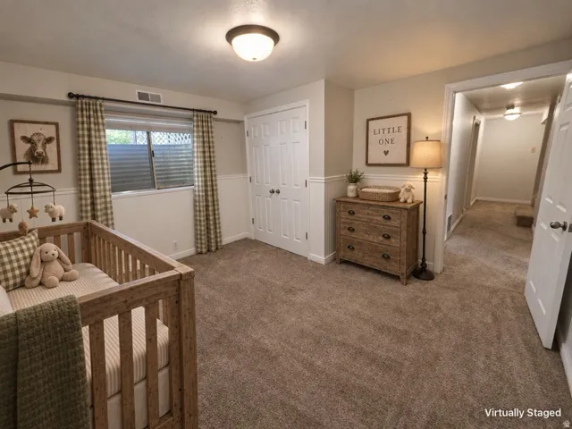 Carpeted room with a double-door closet, wainscoting, and a window with blinds