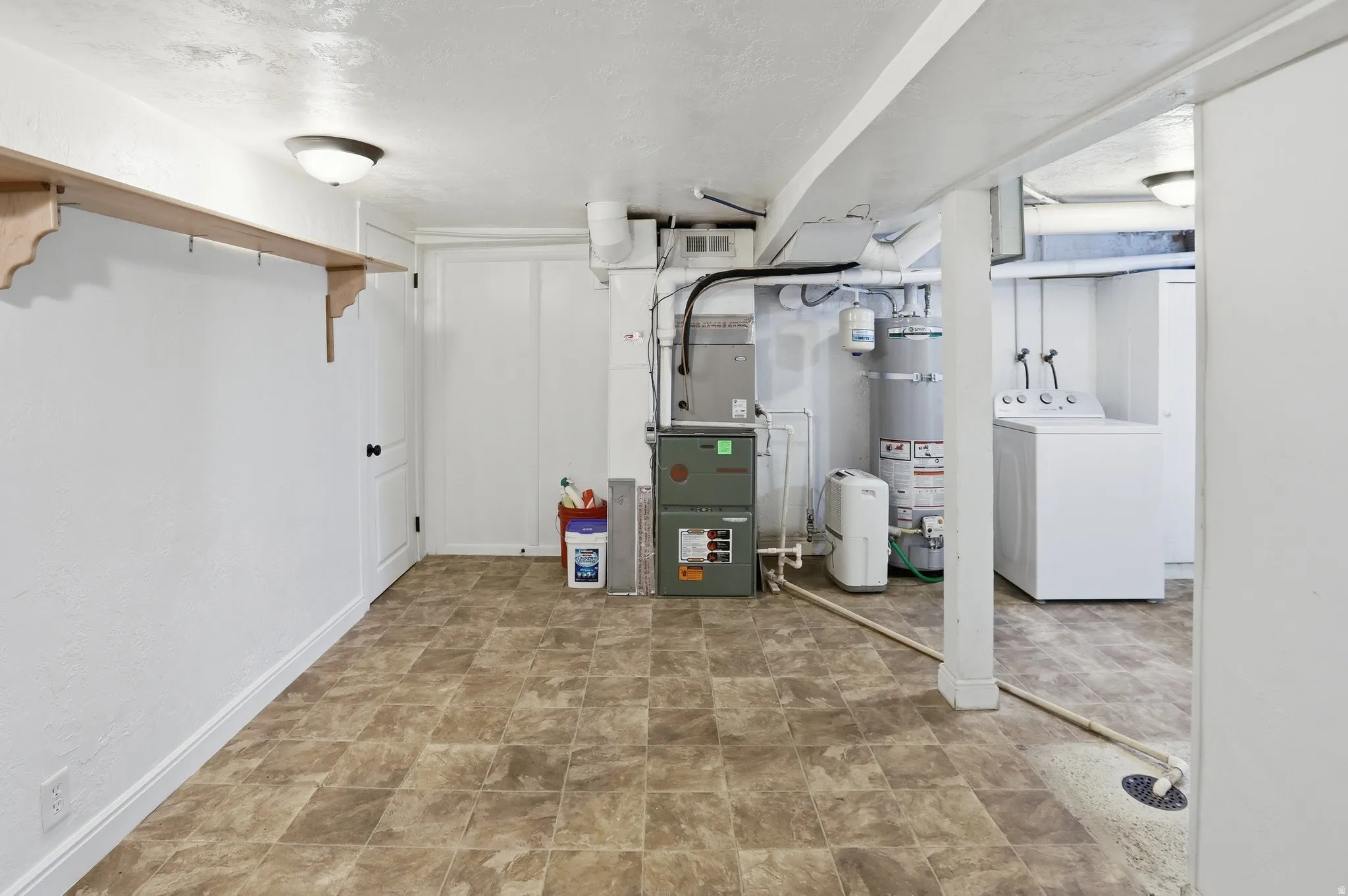 Utility room with tile-finish flooring, built-in shelving, and a water heater