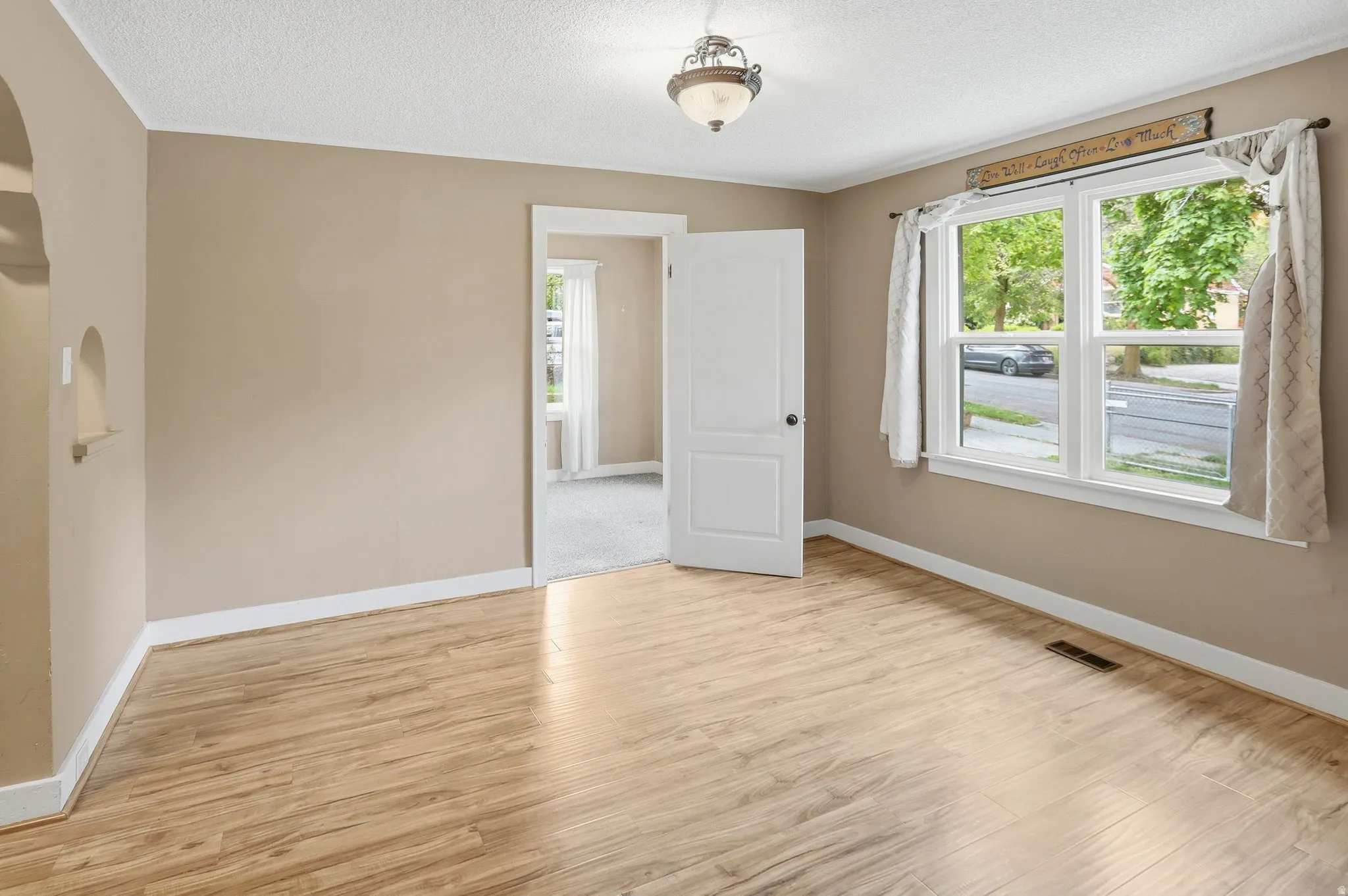 Light wood-finish flooring, neutral wall paint, and white trim