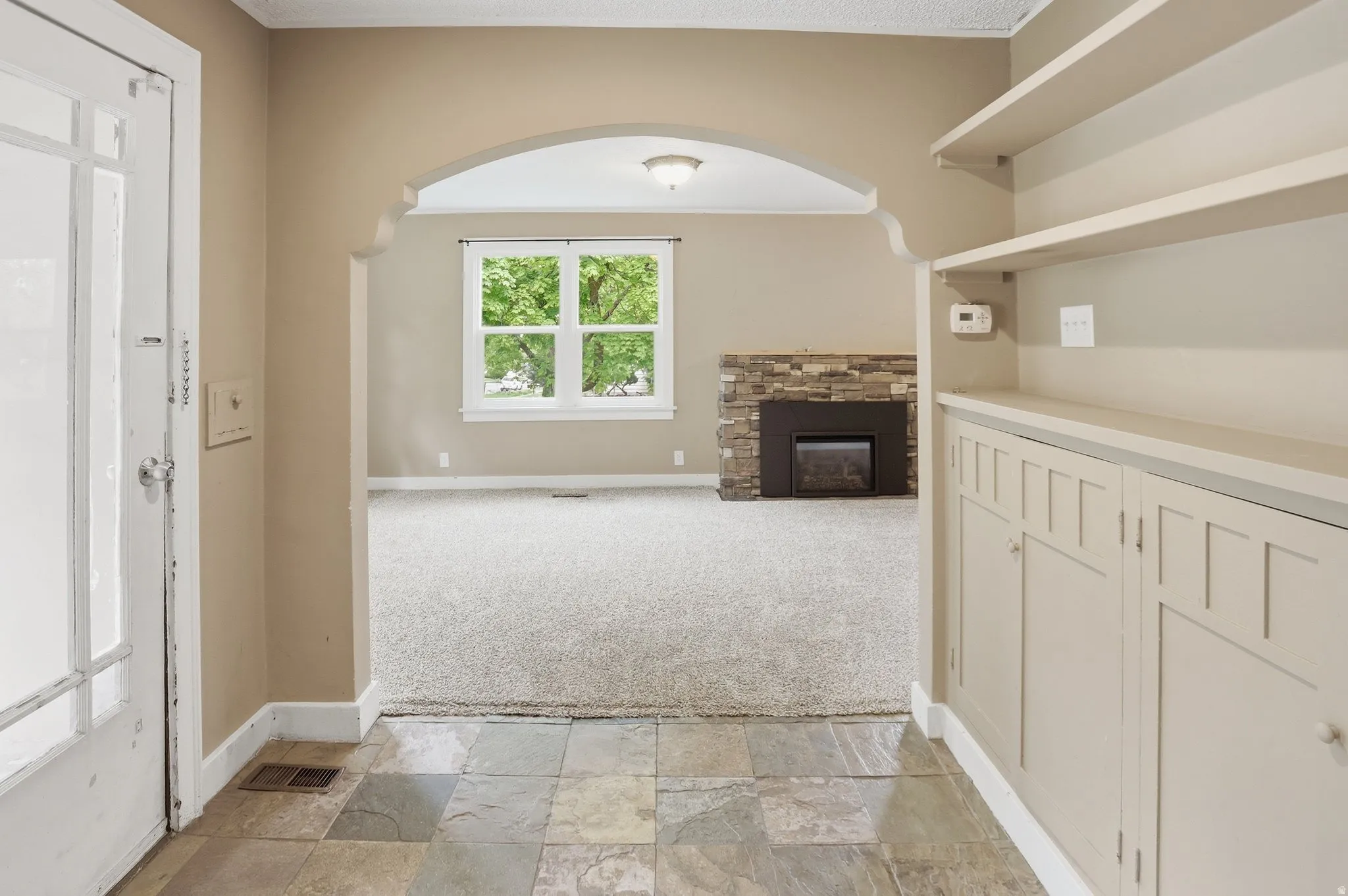 Tiled entryway with built-in cabinetry and shelves