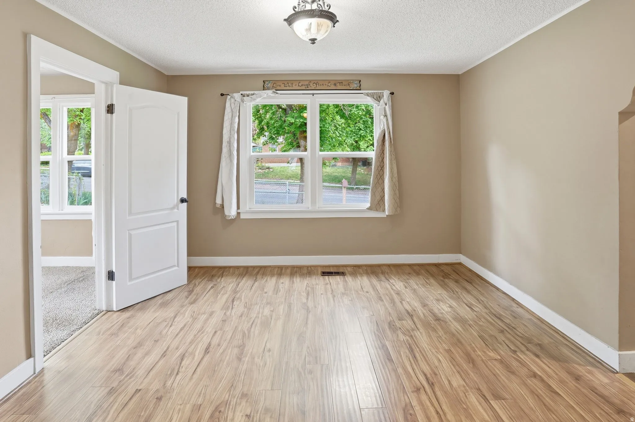Wood-finish flooring, neutral wall tones, and white trim