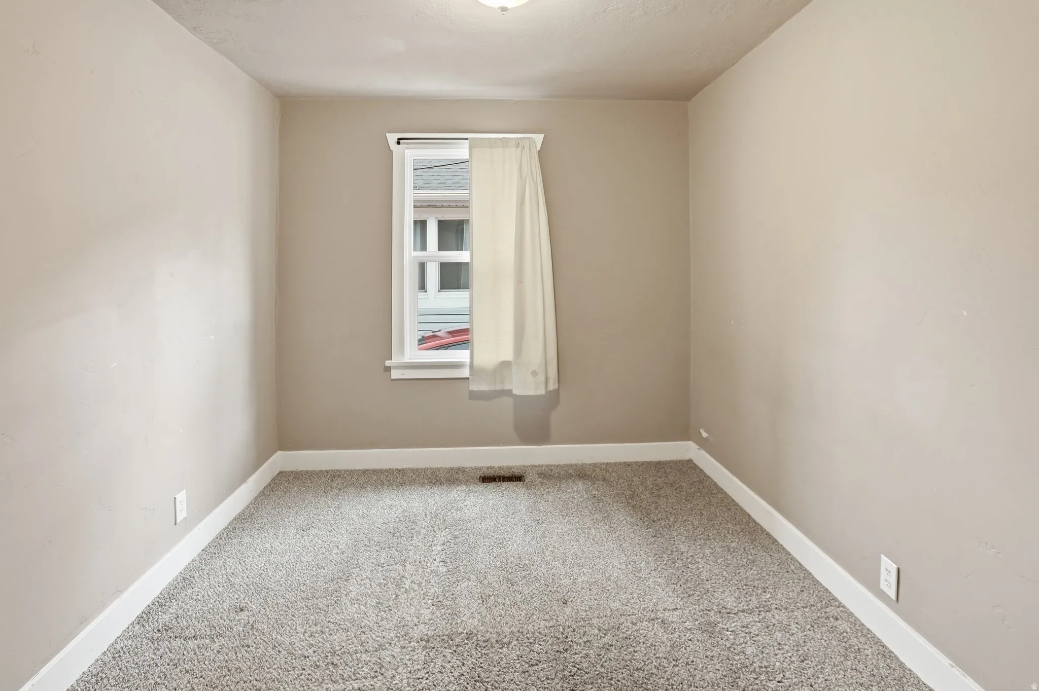 Neutral wall color, window with trim, carpet flooring, ceiling-mounted light fixture, and white baseboards