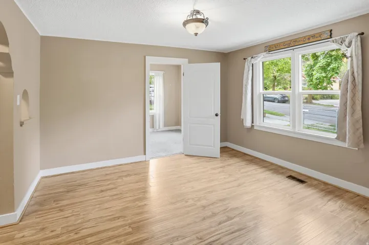 Light wood-finish flooring, neutral wall paint, and white trim
