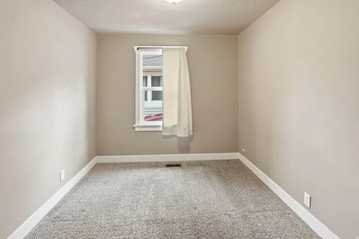 Neutral wall color, window with trim, carpet flooring, ceiling-mounted light fixture, and white baseboards