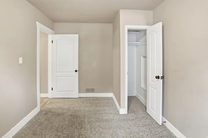 Soft gray carpeting, neutral wall paint, white trim, and white paneled doors