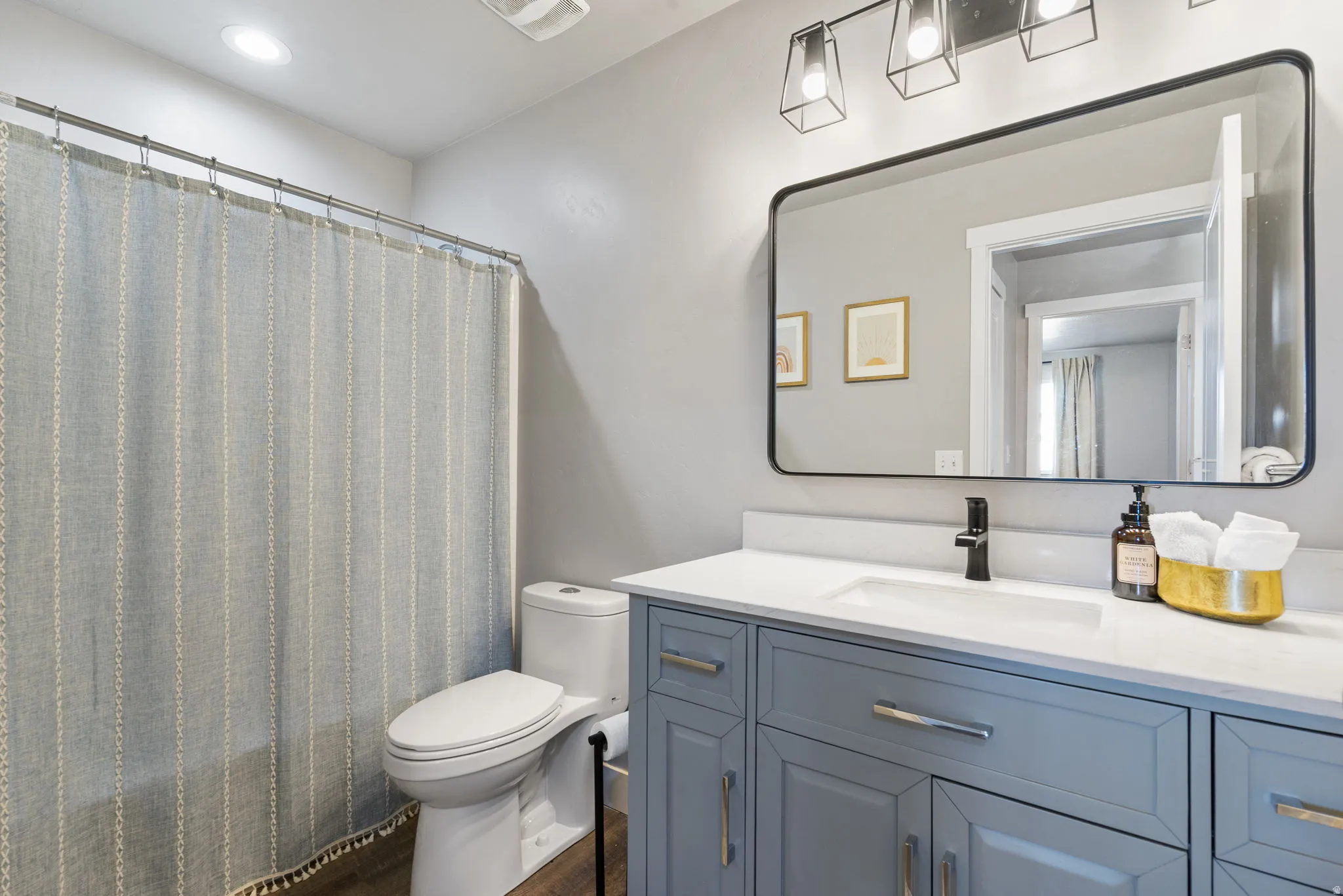 Vanity with light-colored countertop, undermount sink, and matte black faucet