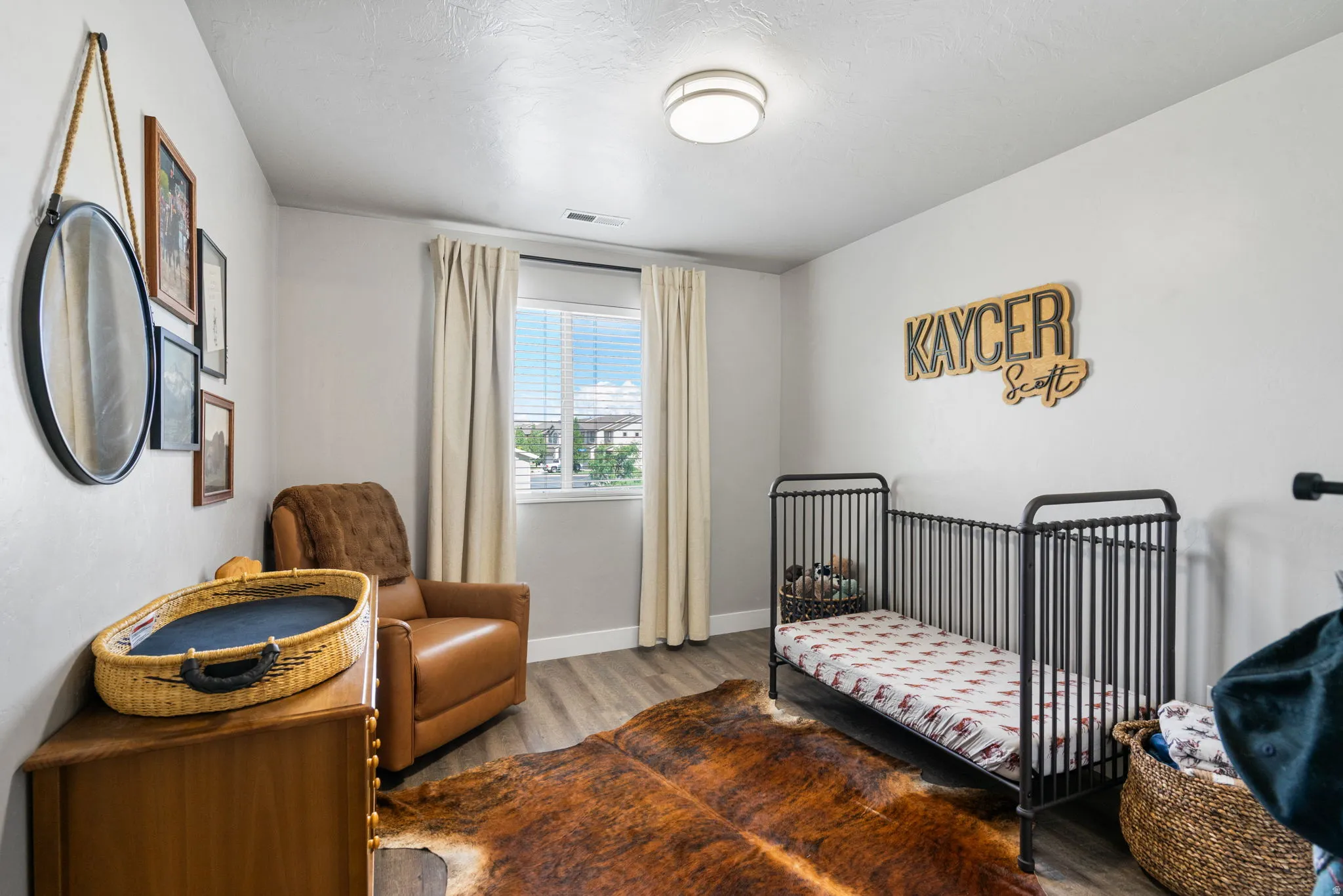 Recessed window with blinds and drapes, wood-finish flooring, and a ceiling-mounted light fixture