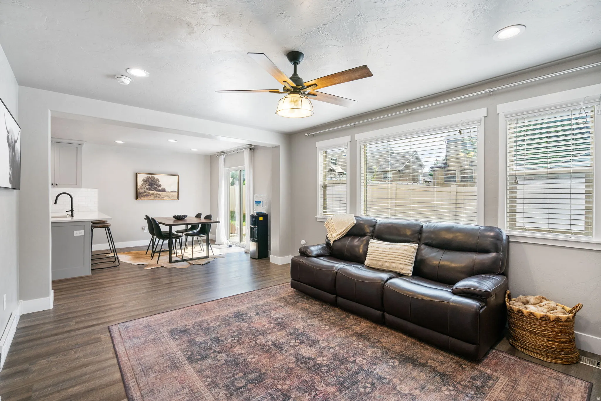 Open-concept living space featuring wood-finish flooring, recessed lighting, and a ceiling fan