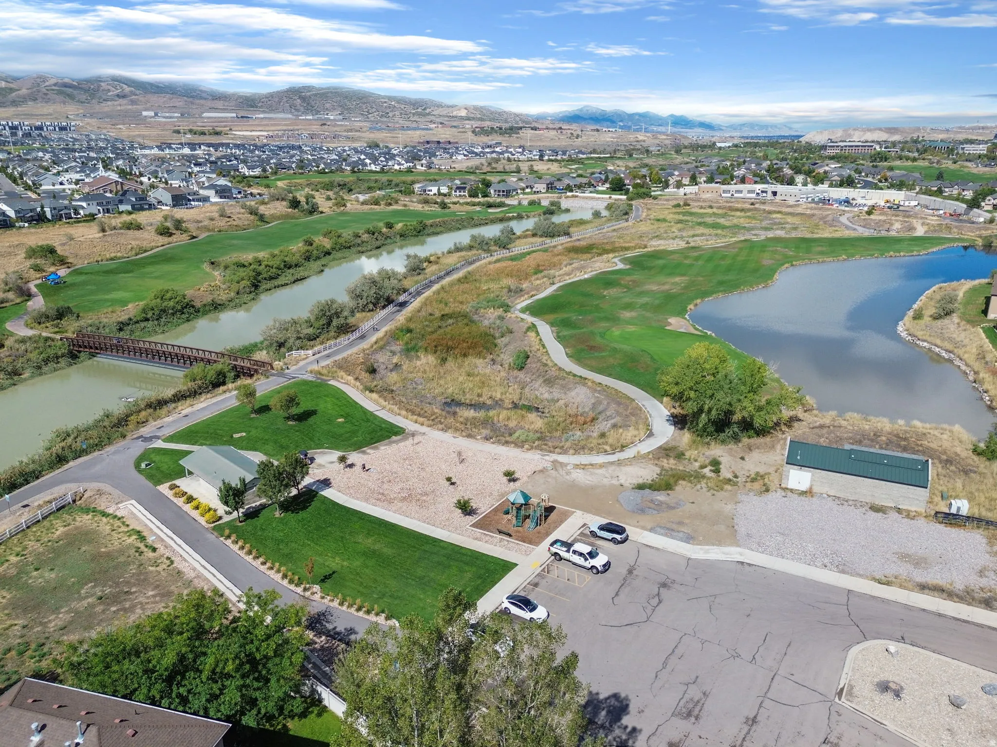Expansive community with a river, bridge, and a large pond