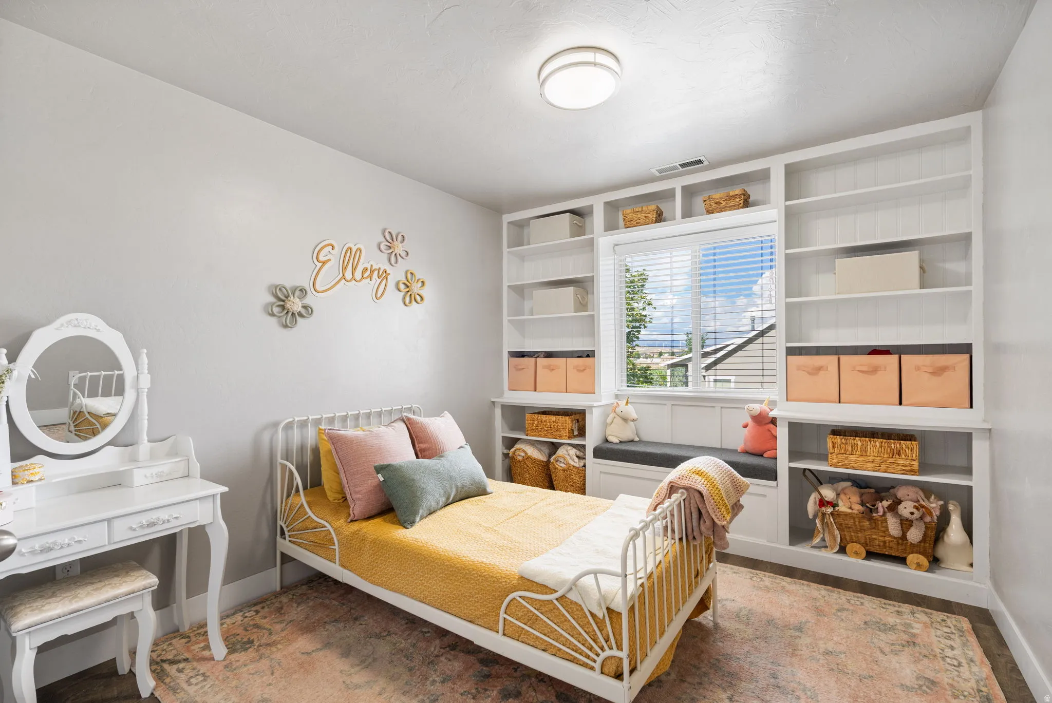 Built-in shelving flanking a window seat, flush mount ceiling light, and light-toned wall finishes