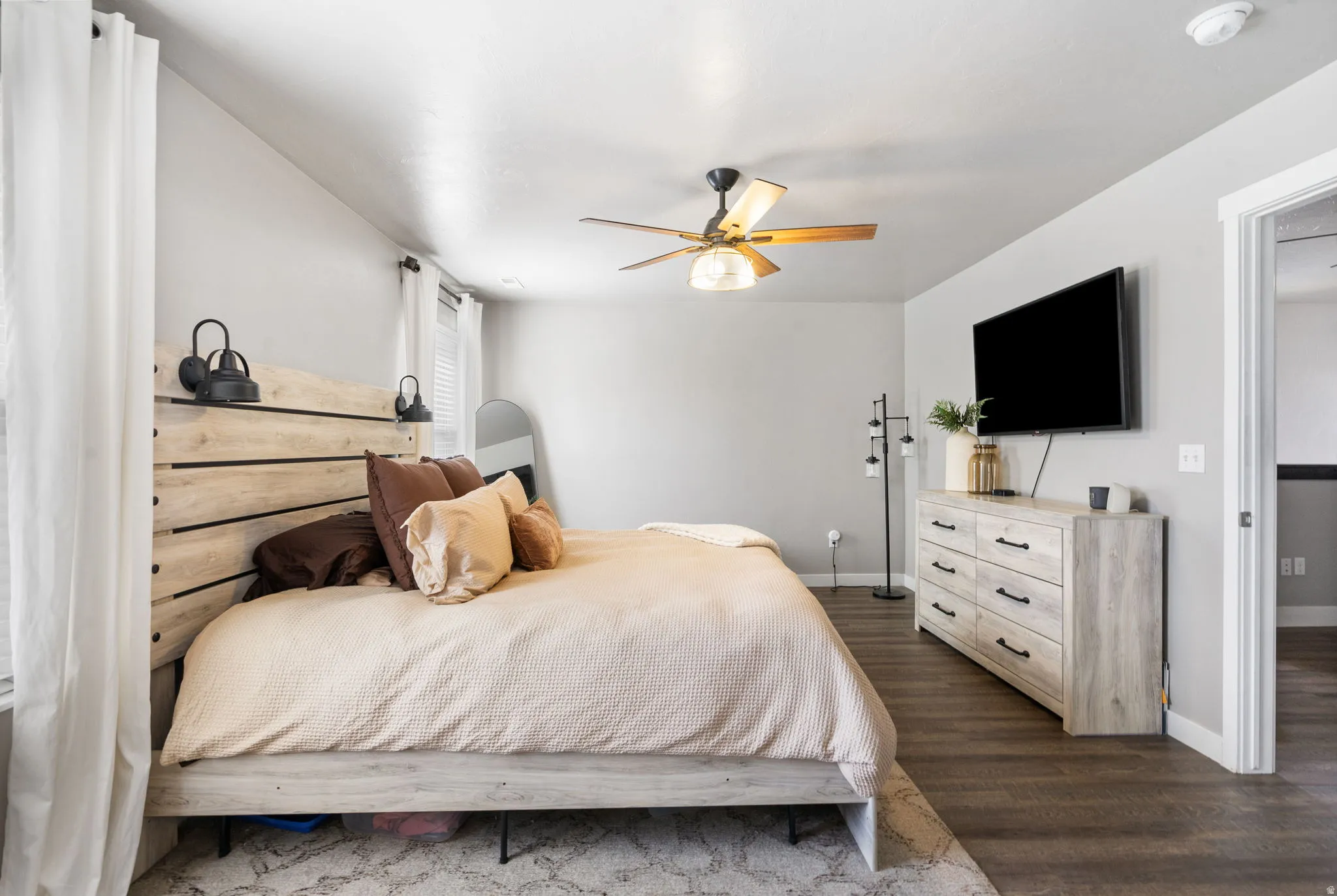 Wood-finish flooring with light gray walls and a ceiling fan