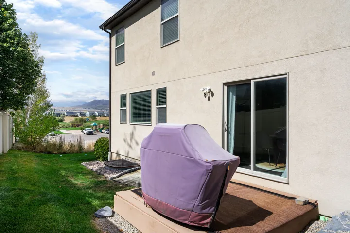 Stucco exterior with multiple windows, sliding glass door, and an exterior light fixture