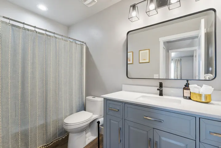Vanity with light-colored countertop, undermount sink, and matte black faucet