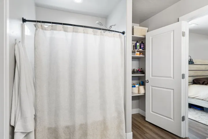 Built-in shelving for storage, white paneled door, wood-finish flooring