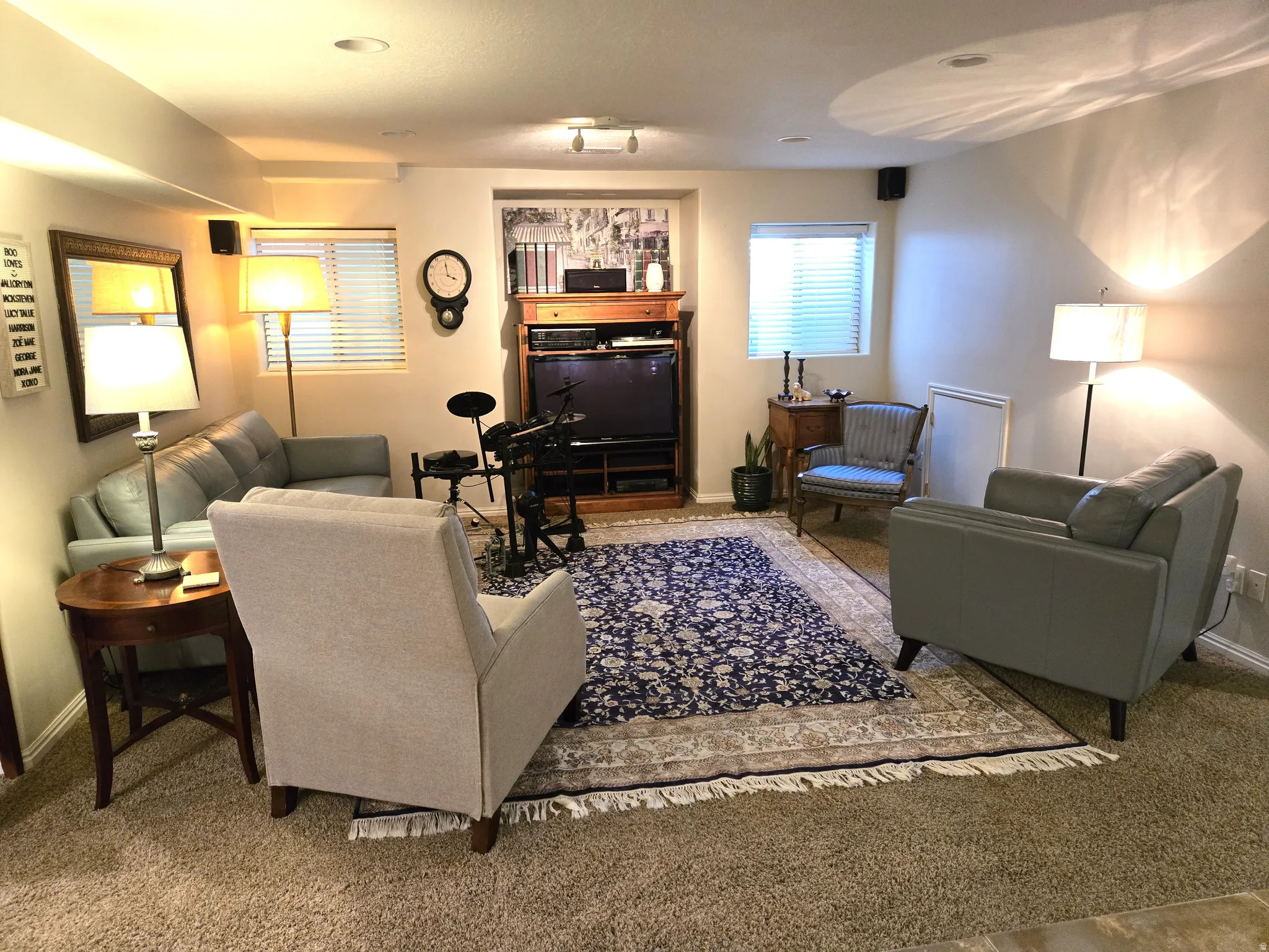 Recessed lighting, wood-finish media console, carpet flooring, and windows with horizontal blinds
