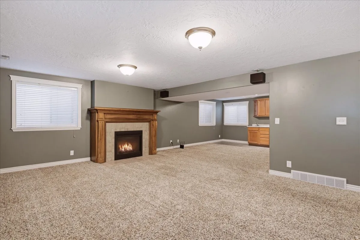 Fireplace with a wood mantel and tile surround