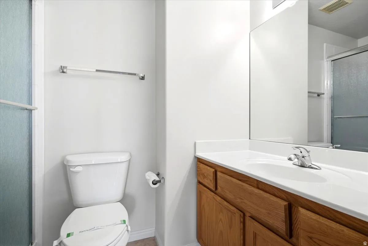 Bathroom with wood-finish vanity, integrated white sink, chrome faucet, and spacious wall-mounted mirror