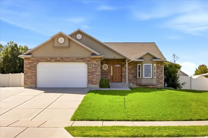 Exterior features a stone veneer facade, stucco accents, an attached garage, and a bay window